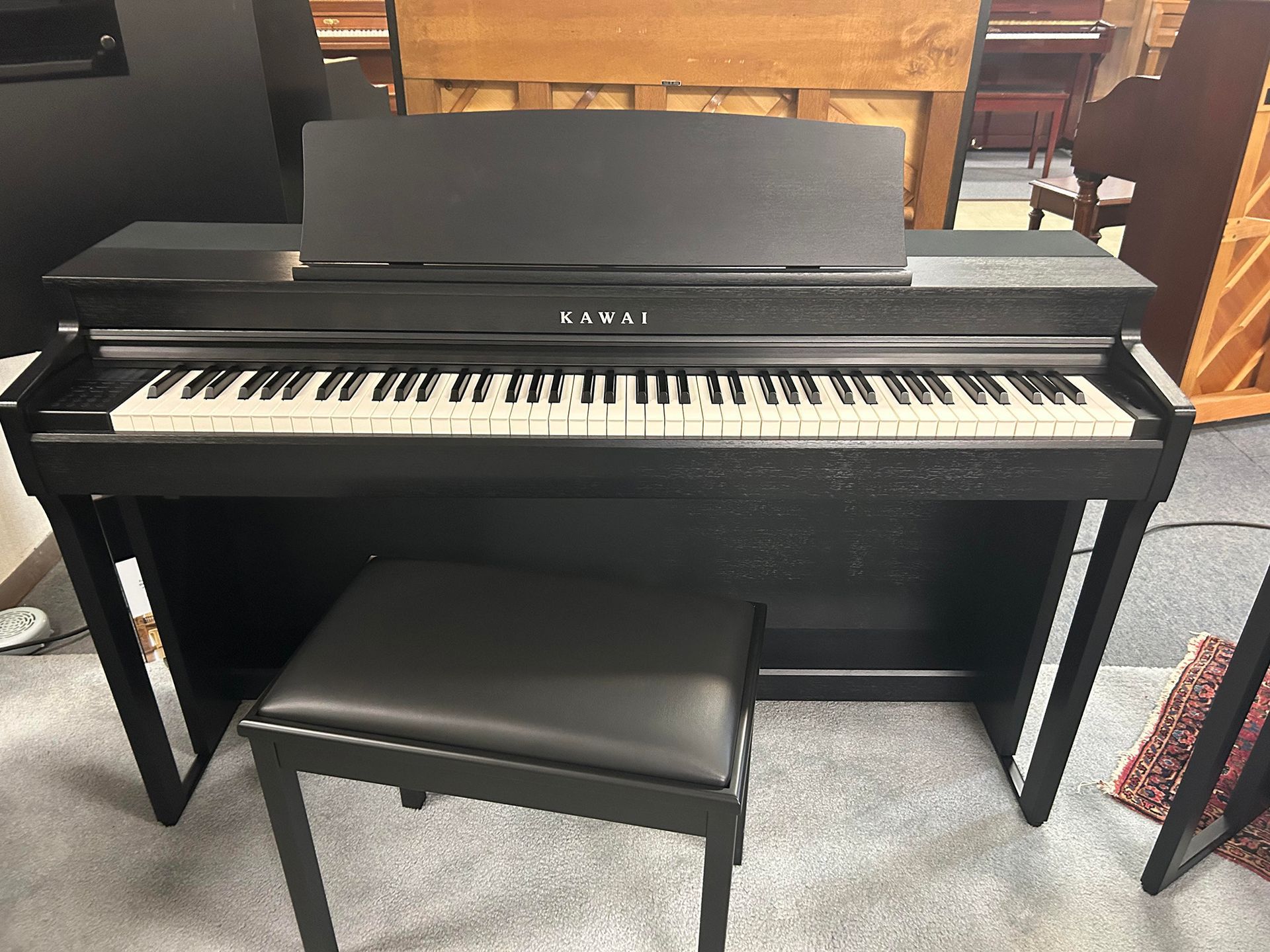 Black Kawai digital piano with bench