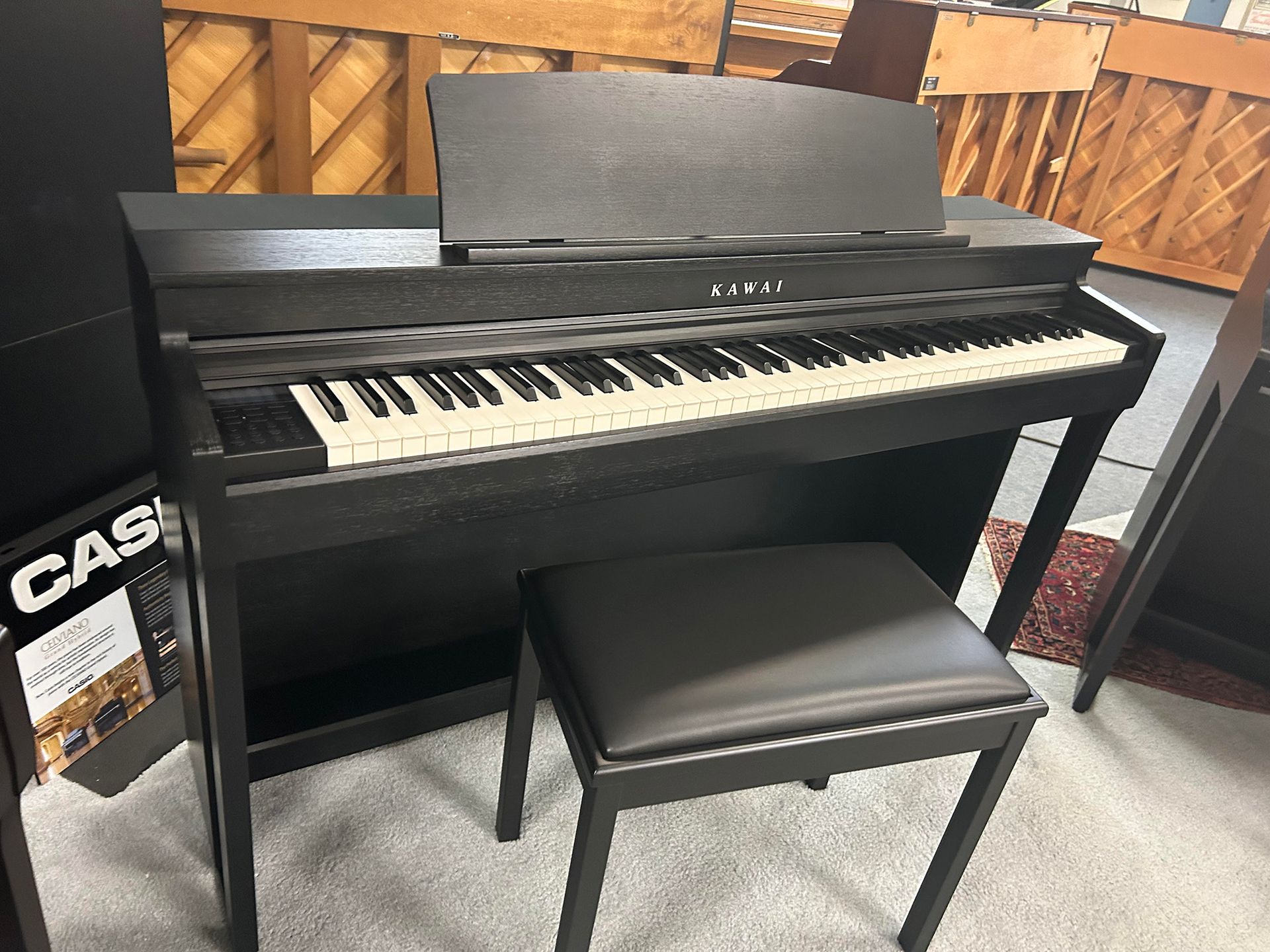 Black digital piano with a bench.