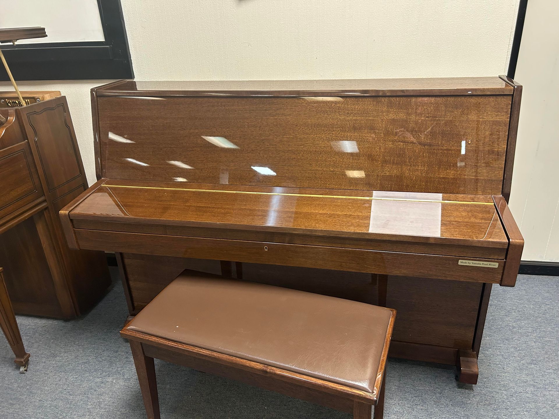 11351 - Pearl River 43, Brown upright piano with matching bench in a room.