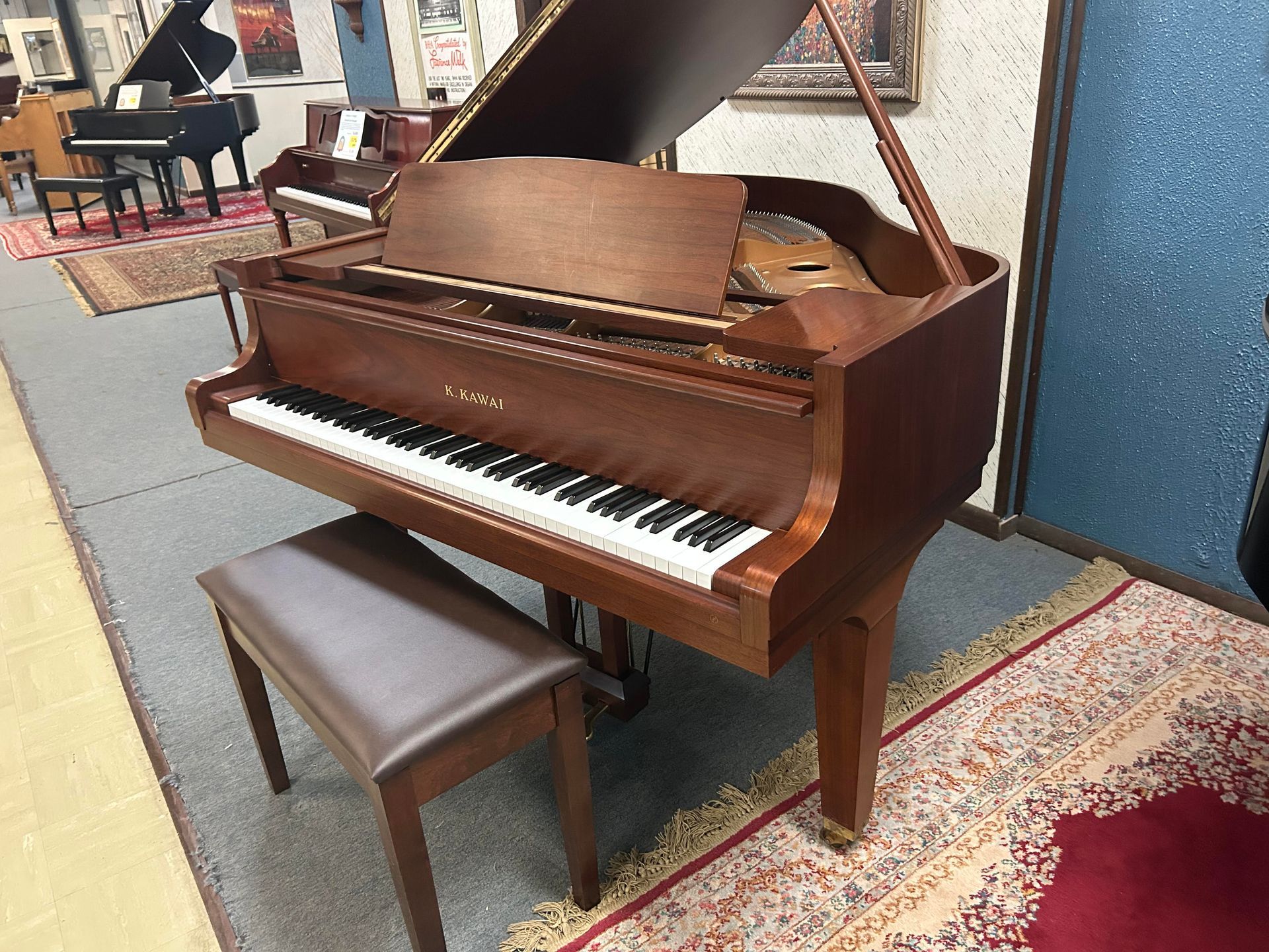 A grand piano is sitting in a room next to a bench.