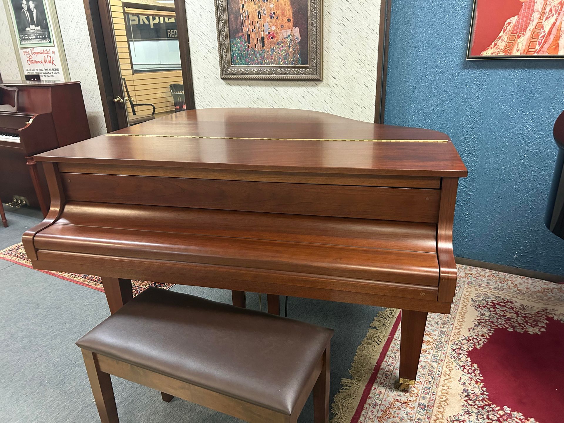 A piano is sitting in a room next to a bench.