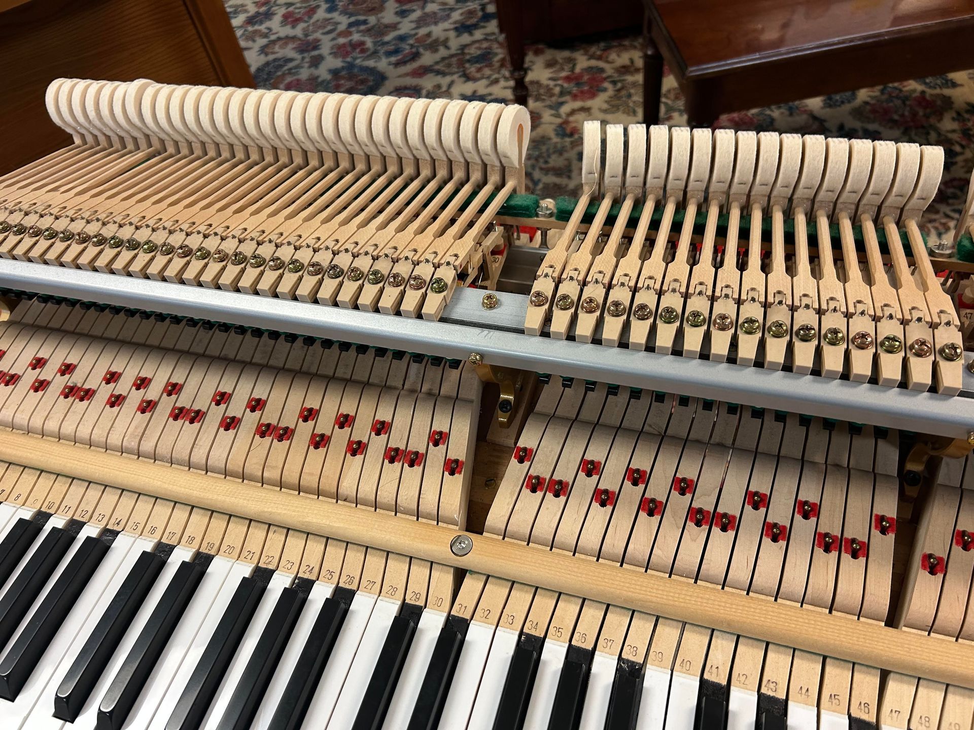 The inside of a piano with a lot of keys and hammers.