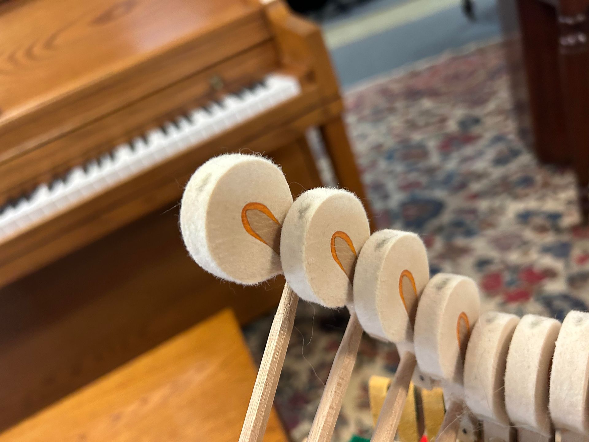 A close up of a piano with a piano in the background