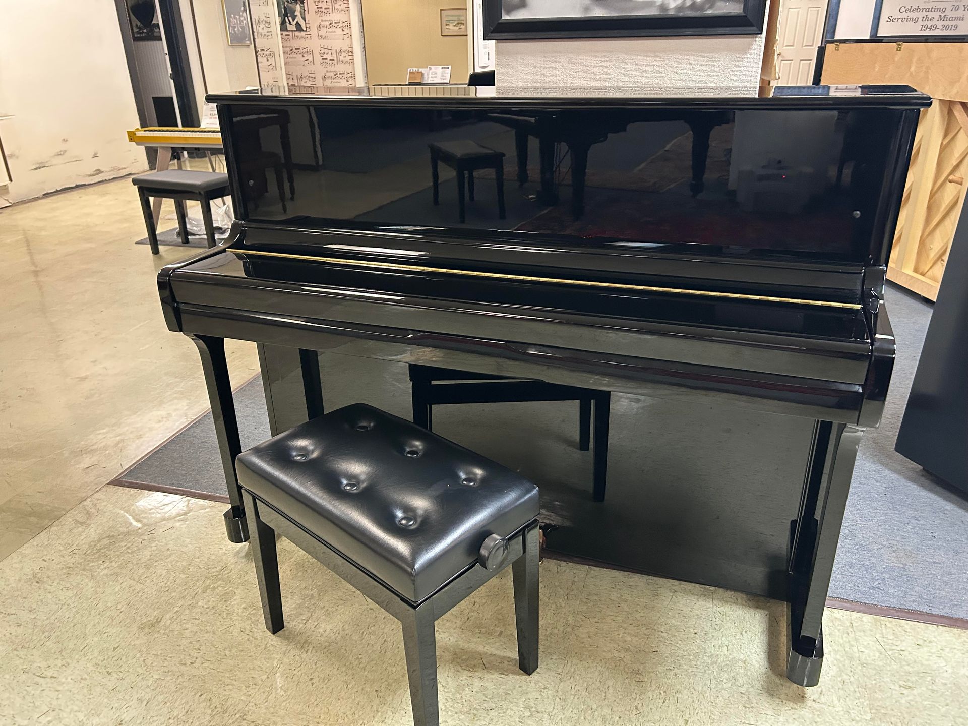 Black piano with a matching bench in a room.