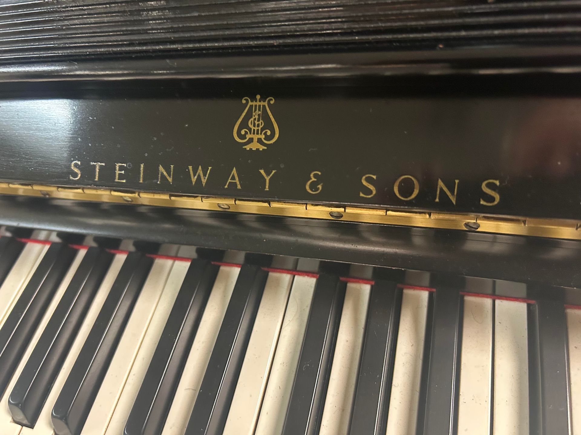Close-up of a black Steinway & Sons piano keyboard with gold lettering.