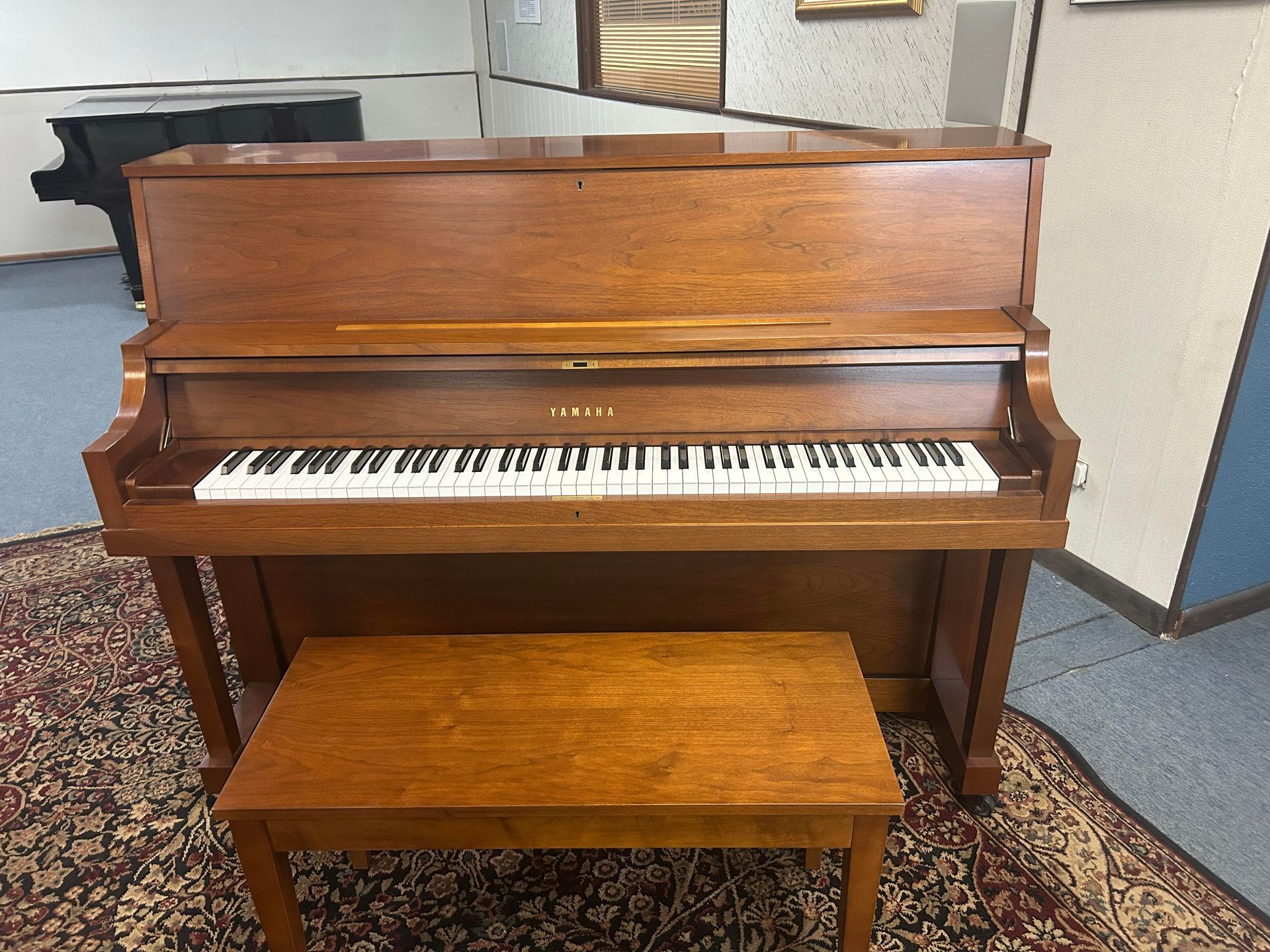 A piano with a bench next to it in a room.