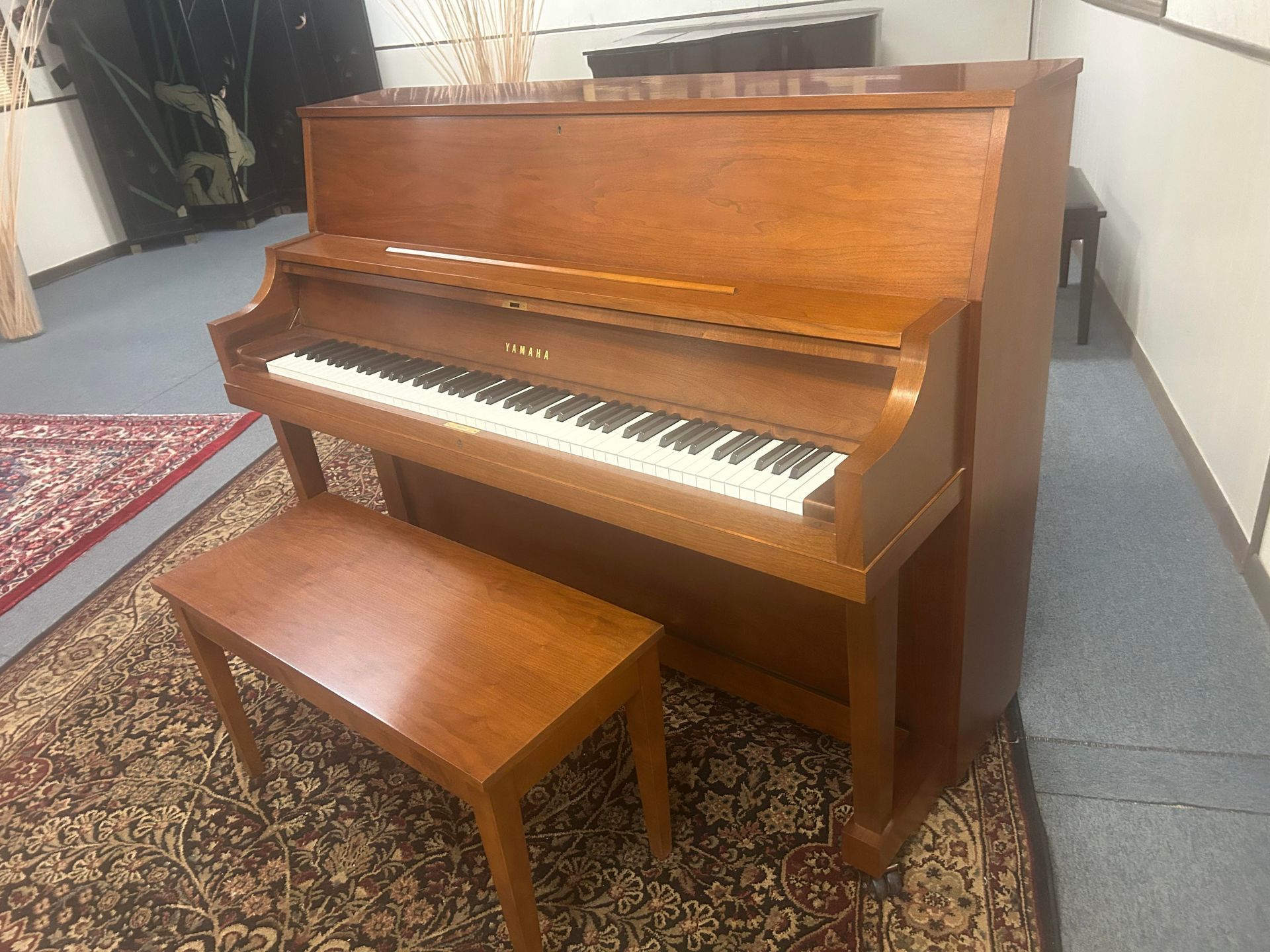 A piano with a bench next to it in a room.