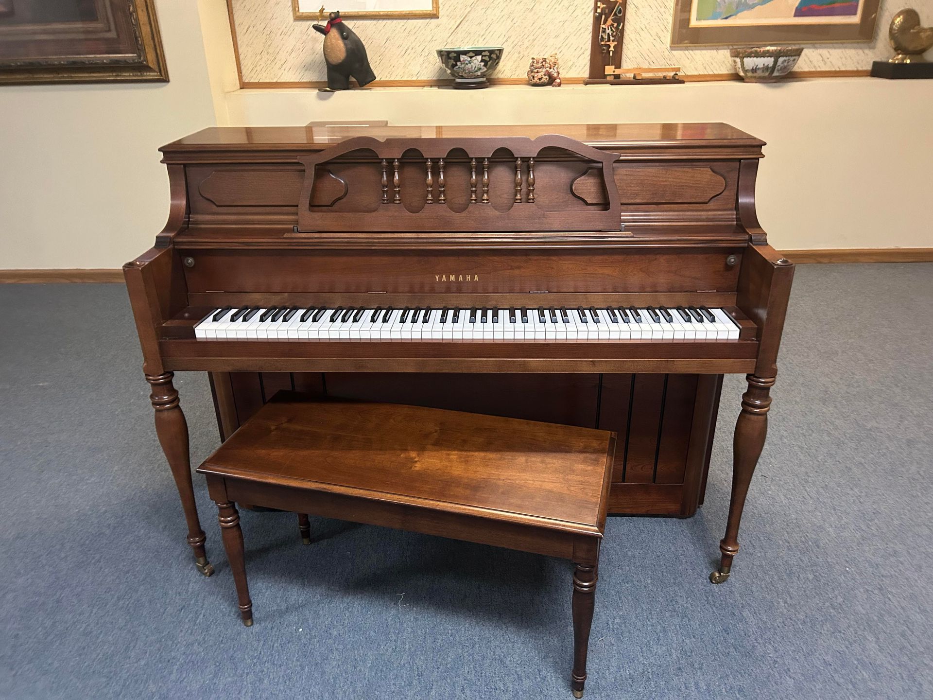 A piano with a bench next to it in a room.