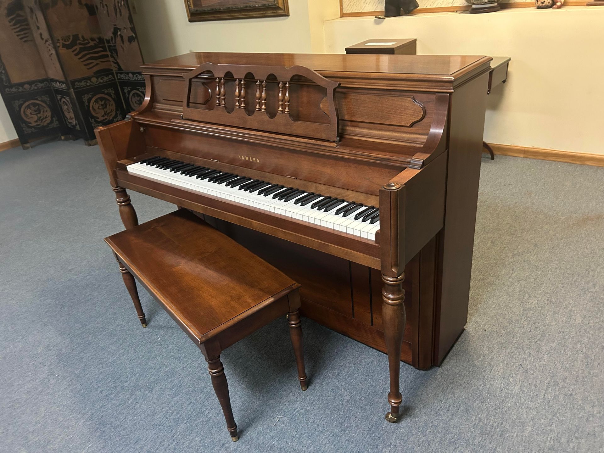 A piano with a bench in a room.