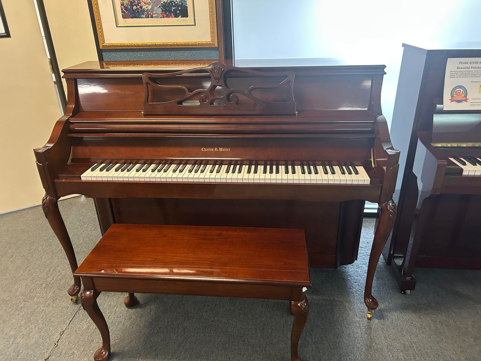 Upright brown piano with a bench; indoors.