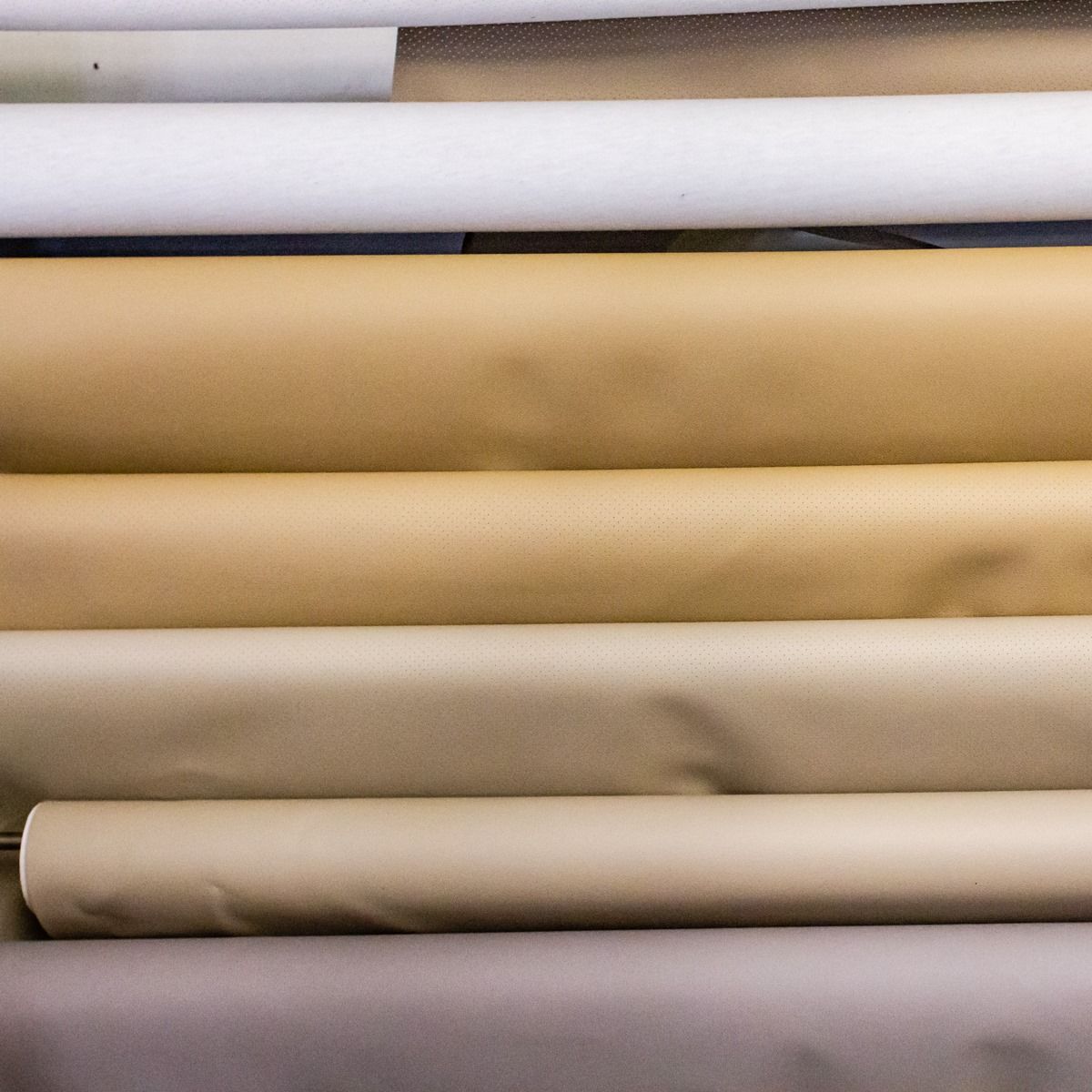 A bunch of rolls of paper are stacked on top of each other on a shelf.