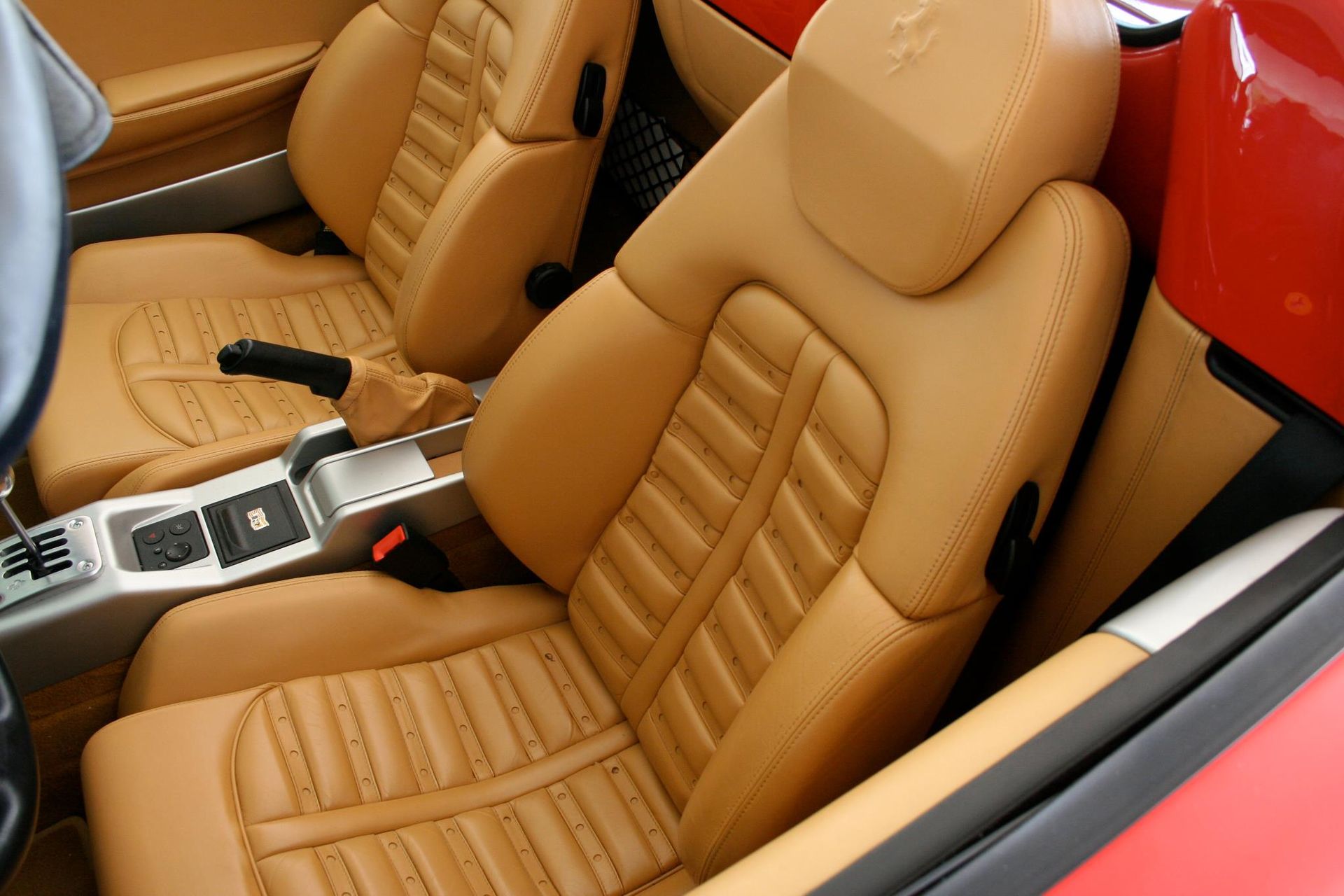 The interior of a ferrari sports car with tan leather seats