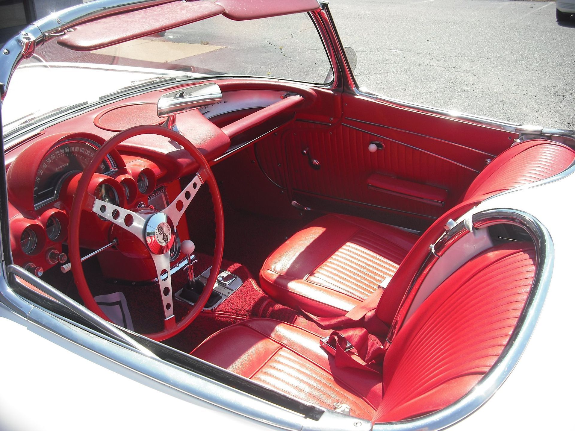 A white car with red seats and a red steering wheel
