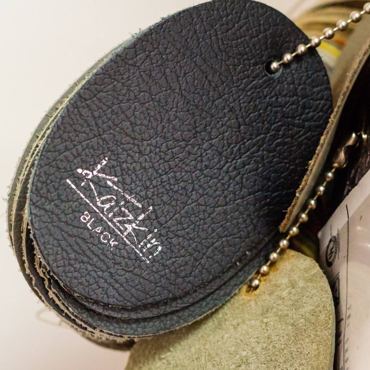 A stack of black leather samples on a chain