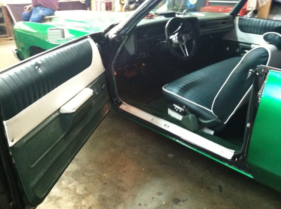 The inside of a green car with the door open