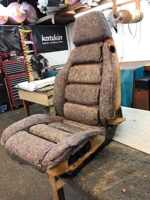 A chair in a garage with a katzkin sign behind it
