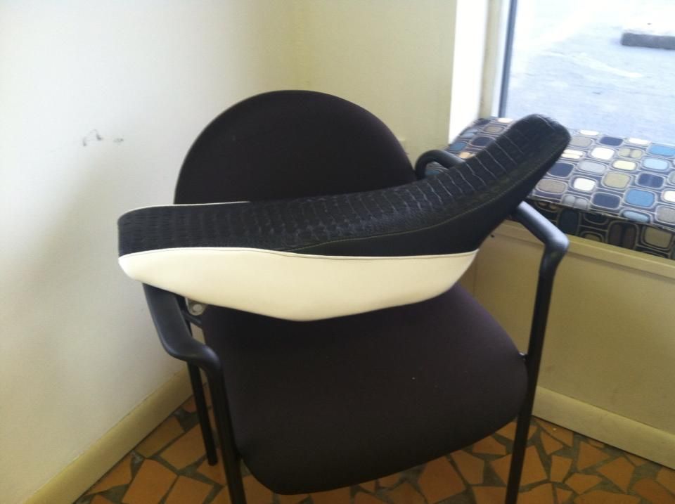 A black chair with a white cushion on it