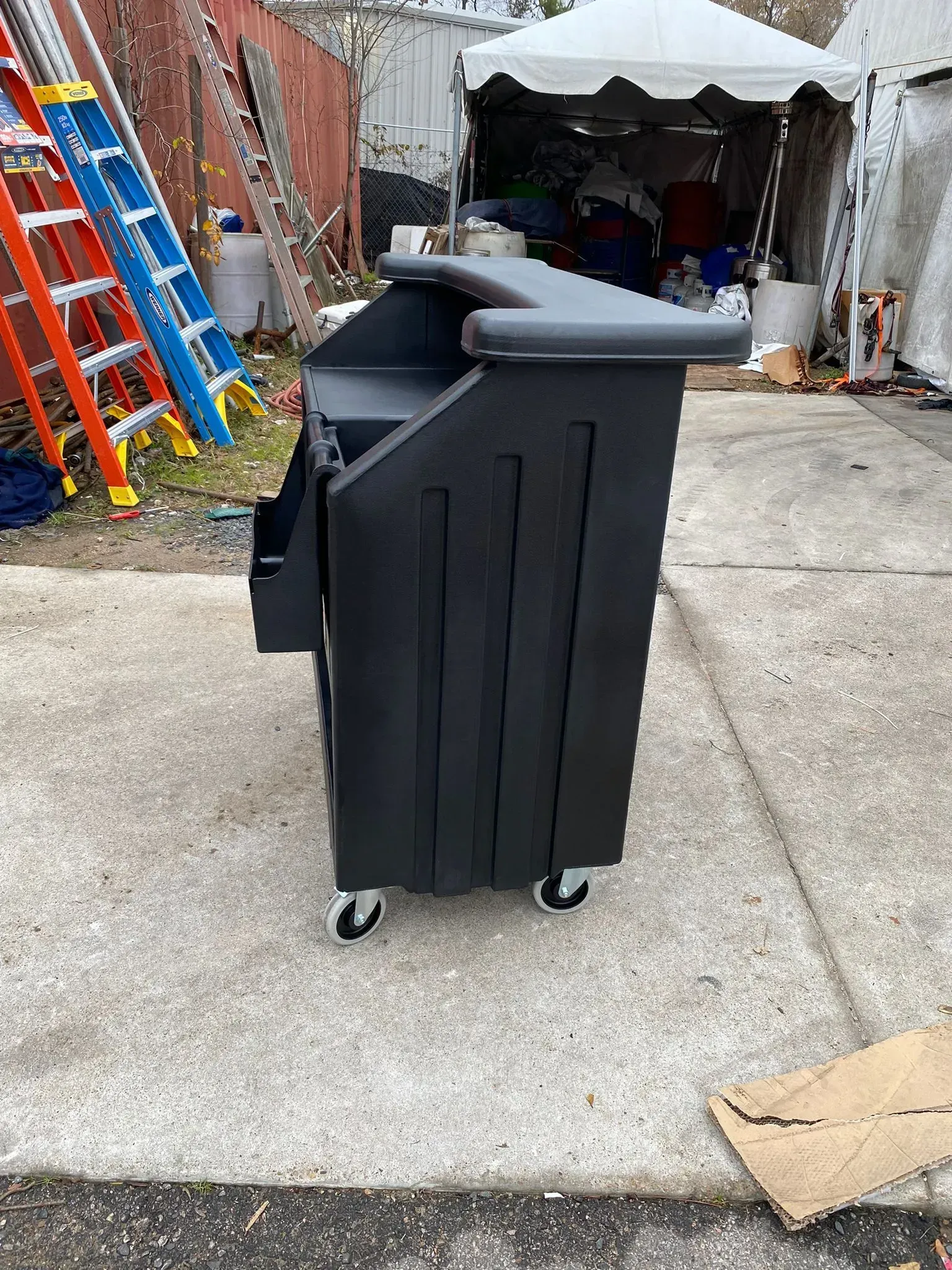 Black portable podium on wheels, in outdoor setting.