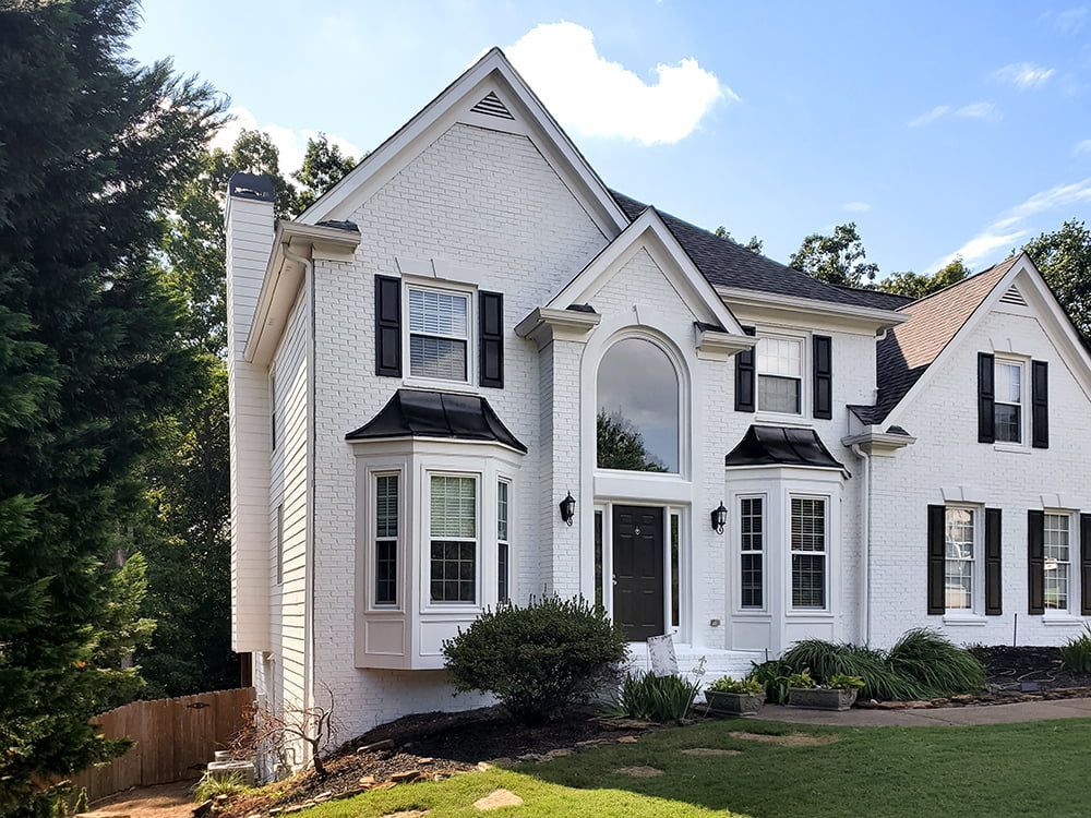 A large white house with black shutters on the windows