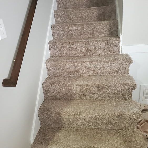 The stairs are carpeted and have a wooden railing.