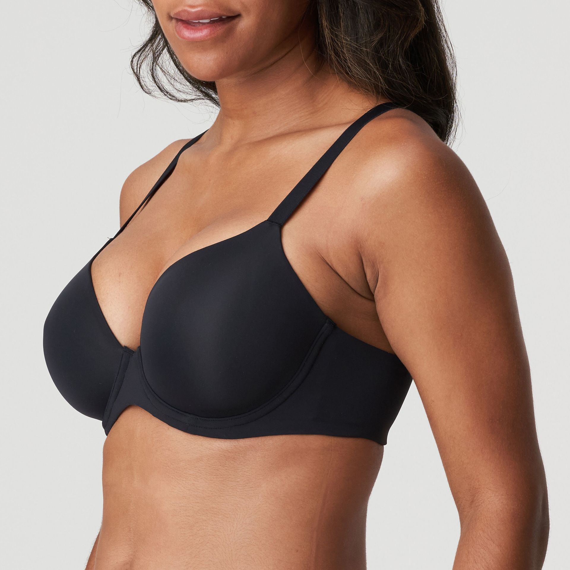 A woman is wearing a black bra and smiling