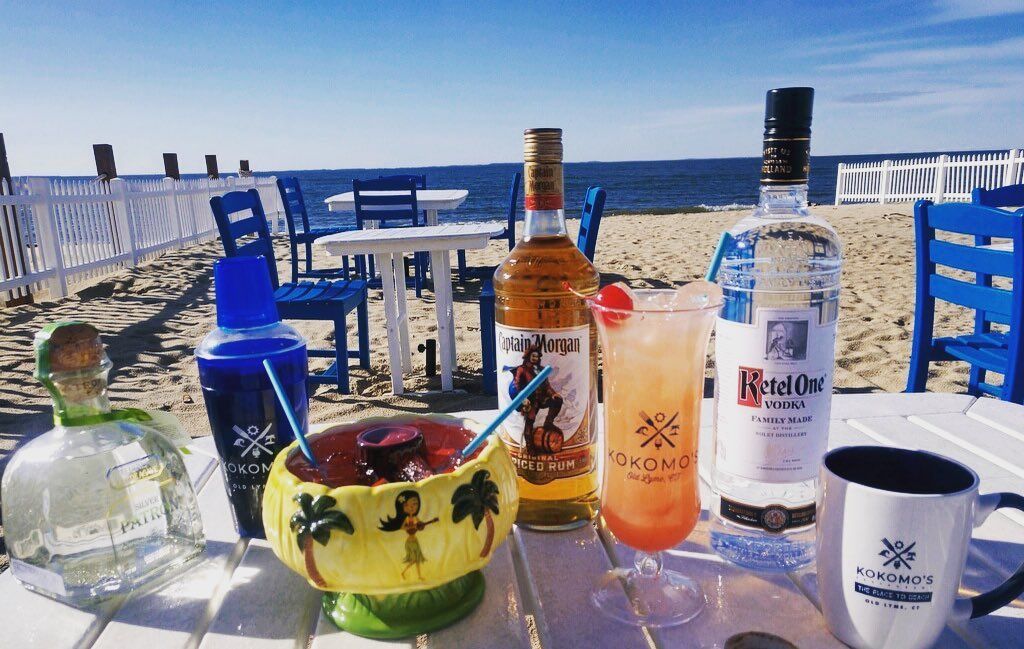 A table with drinks and bottles on it on the beach
