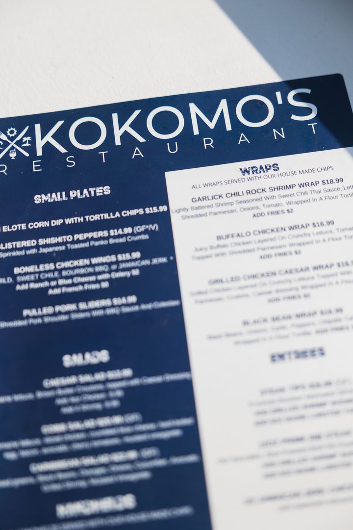 Menu from Kokomo's Restaurant in dark blue and white. Offers small plates, salads, and entrees.