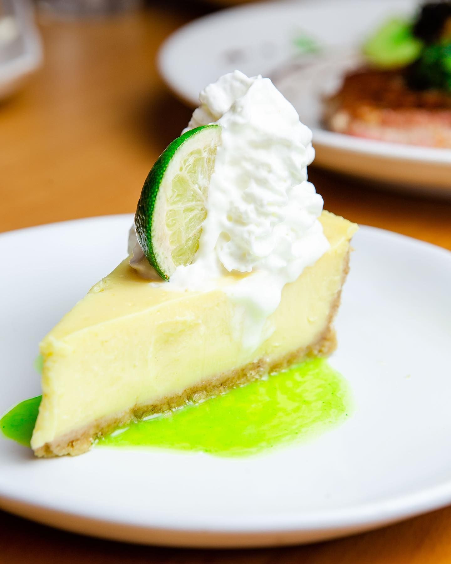 A slice of key lime pie on a white plate
