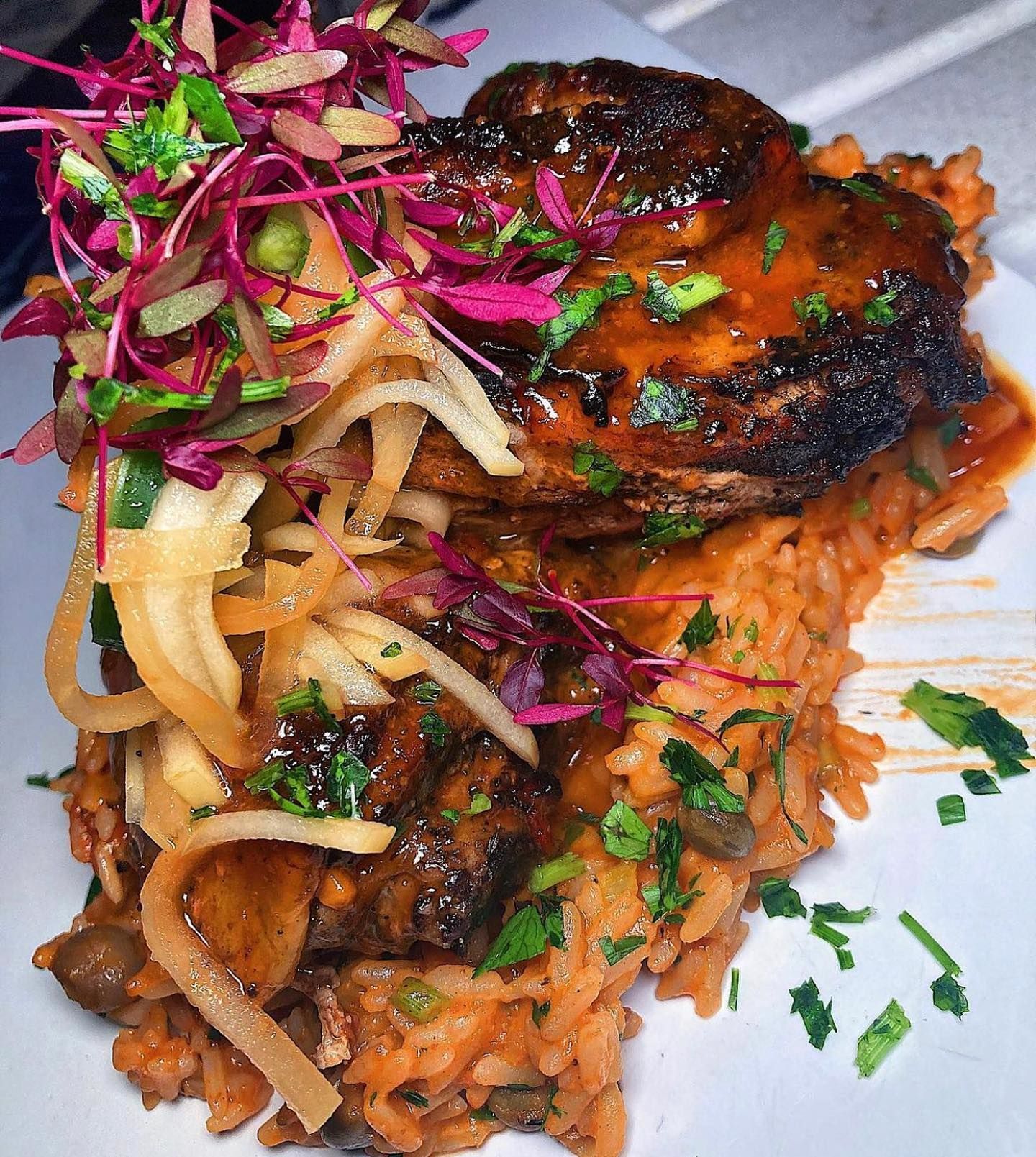 A close up of a plate of food with rice and meat on a table.