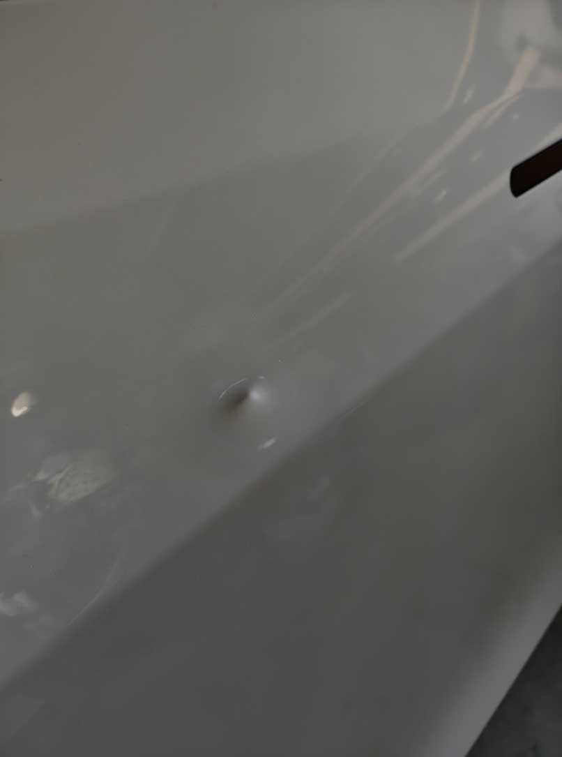 White car panel with a small dent.