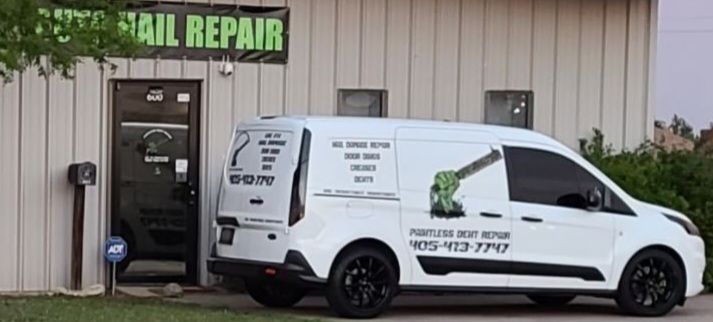 White van in front of a building with a sign that reads 