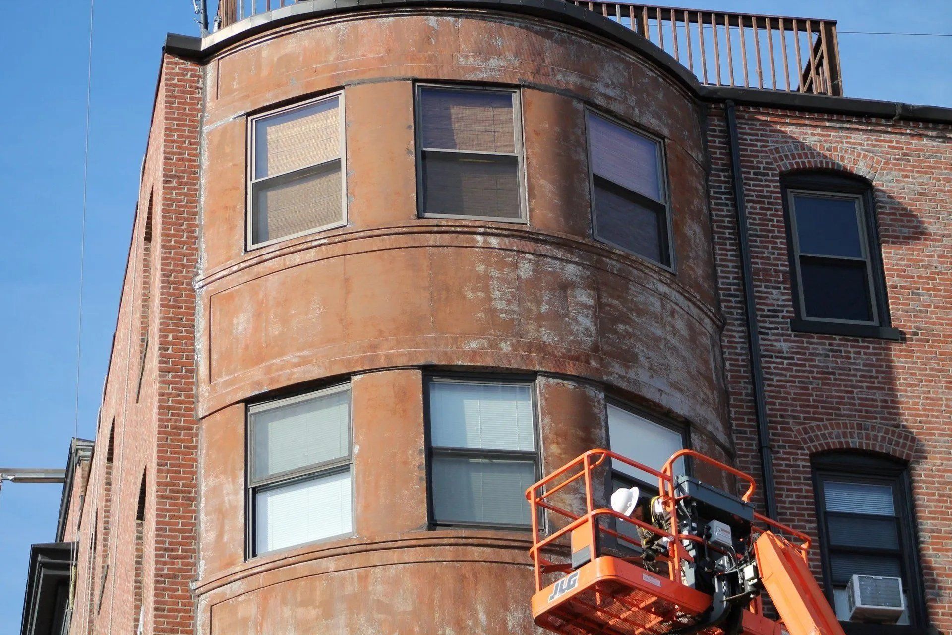 Man on a lift platform repairing the side of a building
