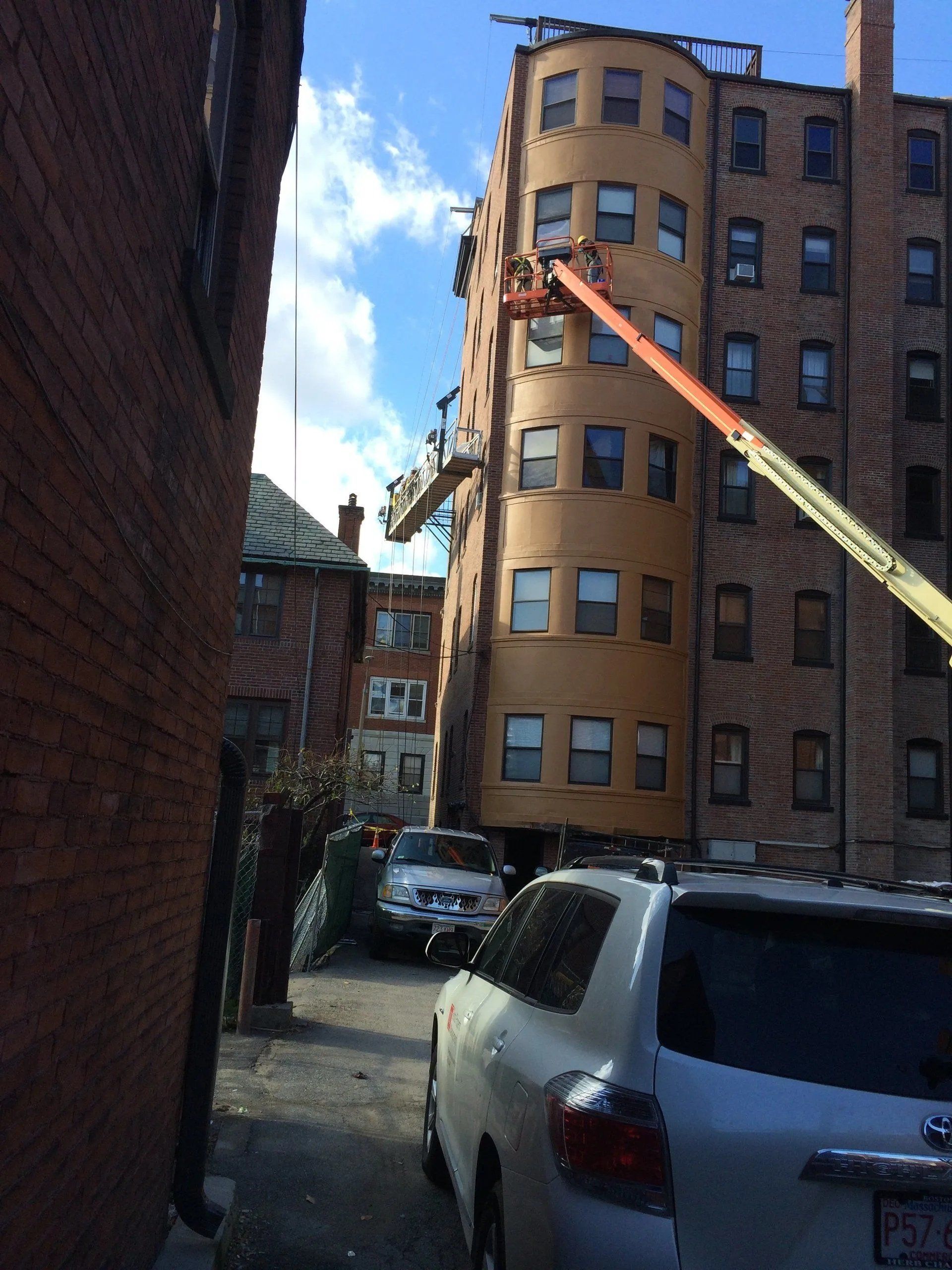 Man on a lift platform repairing the side of a building