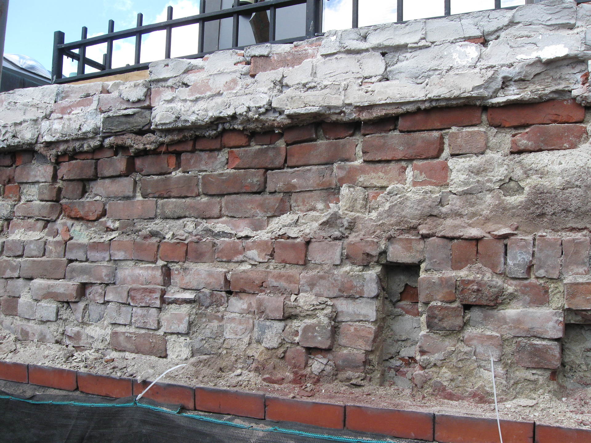 Badly damaged brick wall that needs repairing