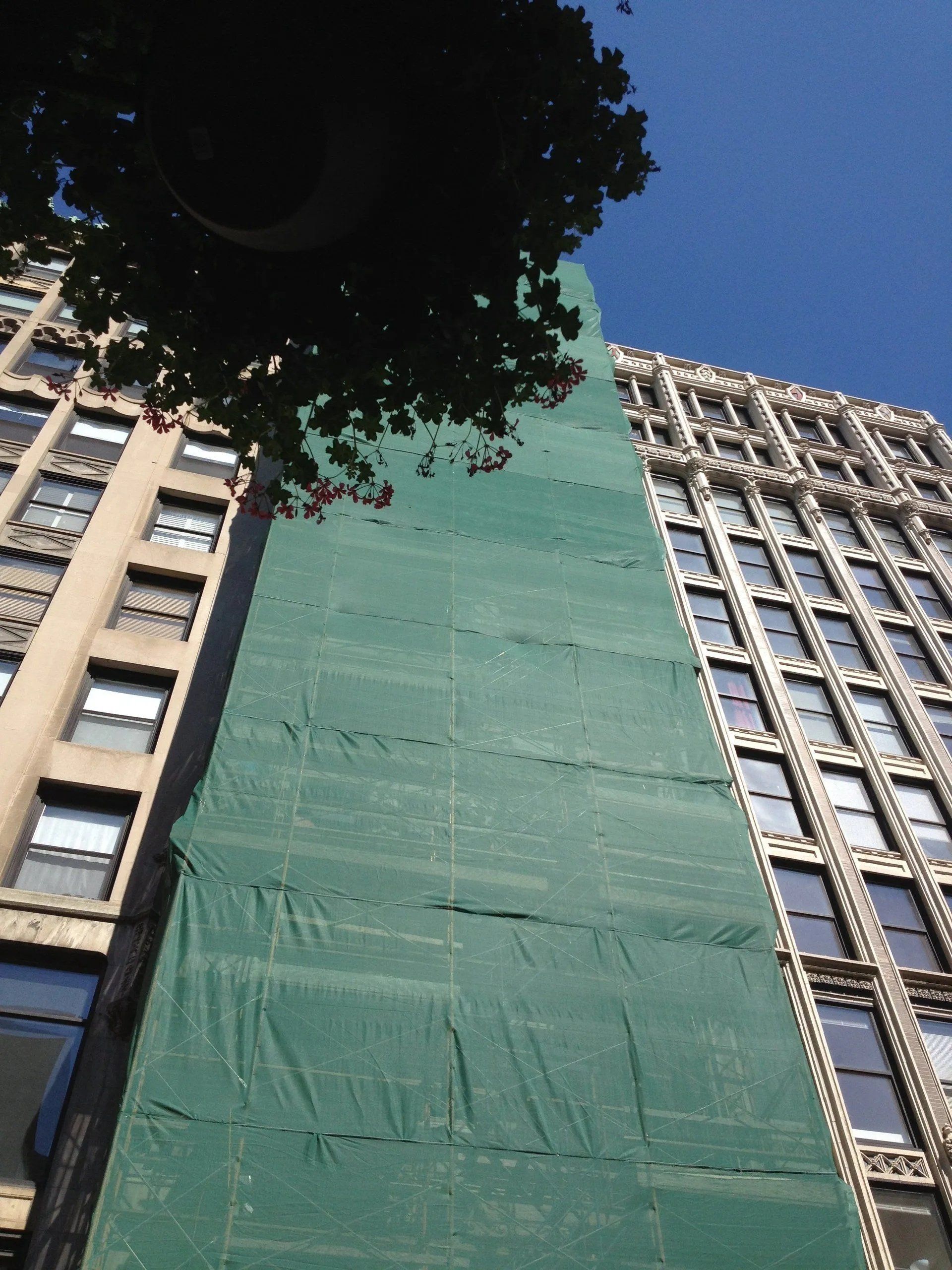 Building under construction with green safety net