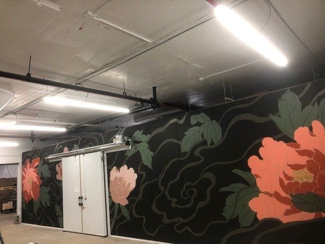 A room with a mural of flowers on the wall