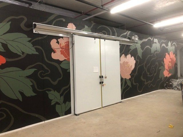 A wall with flowers painted on it and a sliding door
