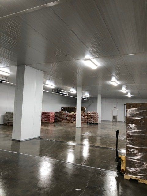 A large warehouse filled with lots of boxes and pallets.
