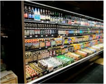 A refrigerated section of a grocery store filled with lots of bottles of beer.