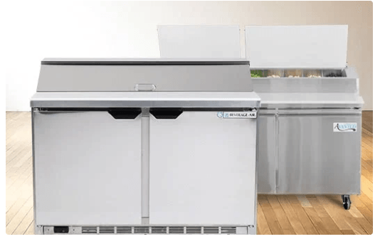 A white refrigerator and a stainless steel refrigerator are sitting on a wooden floor.