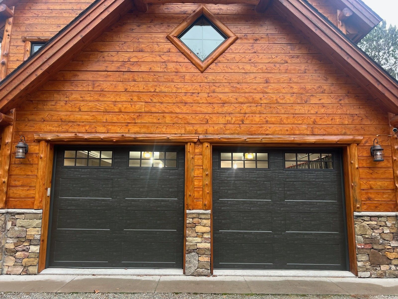 Wooden garage with two black doors and a stone base, front view with a small diamond window.