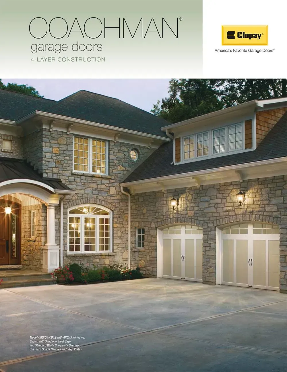 Stone two-story house exterior with arched entry, double garage, and lit windows at dusk