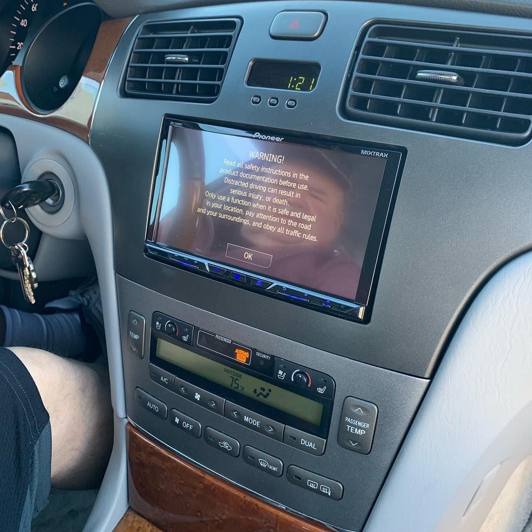 A person is sitting in a car with a thermostat on the dashboard