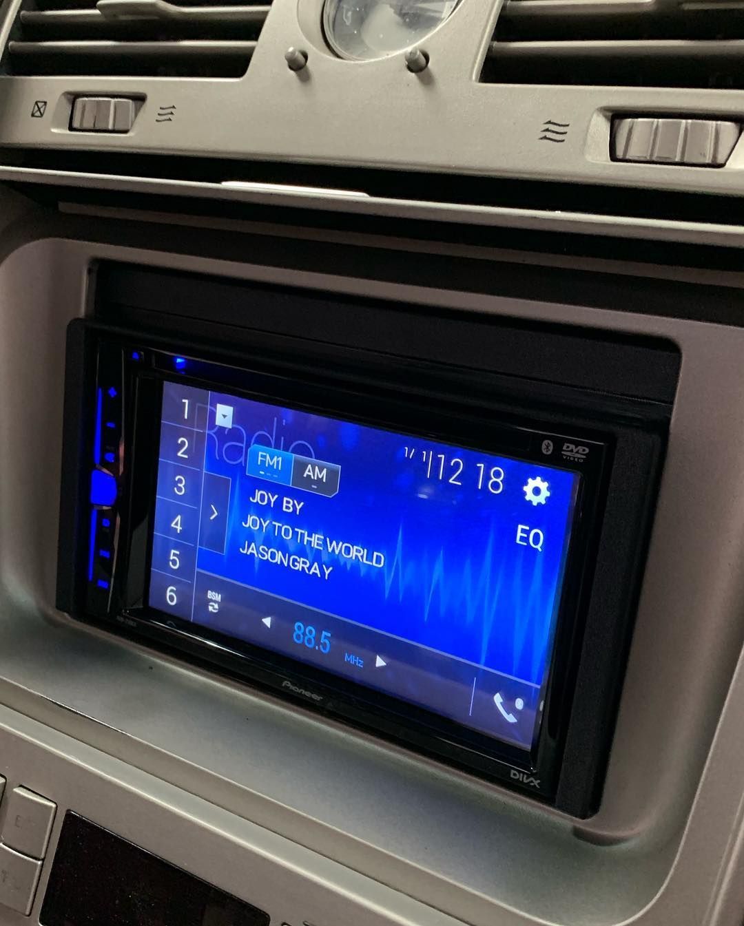 A car stereo with a blue screen that says 12 18 on it