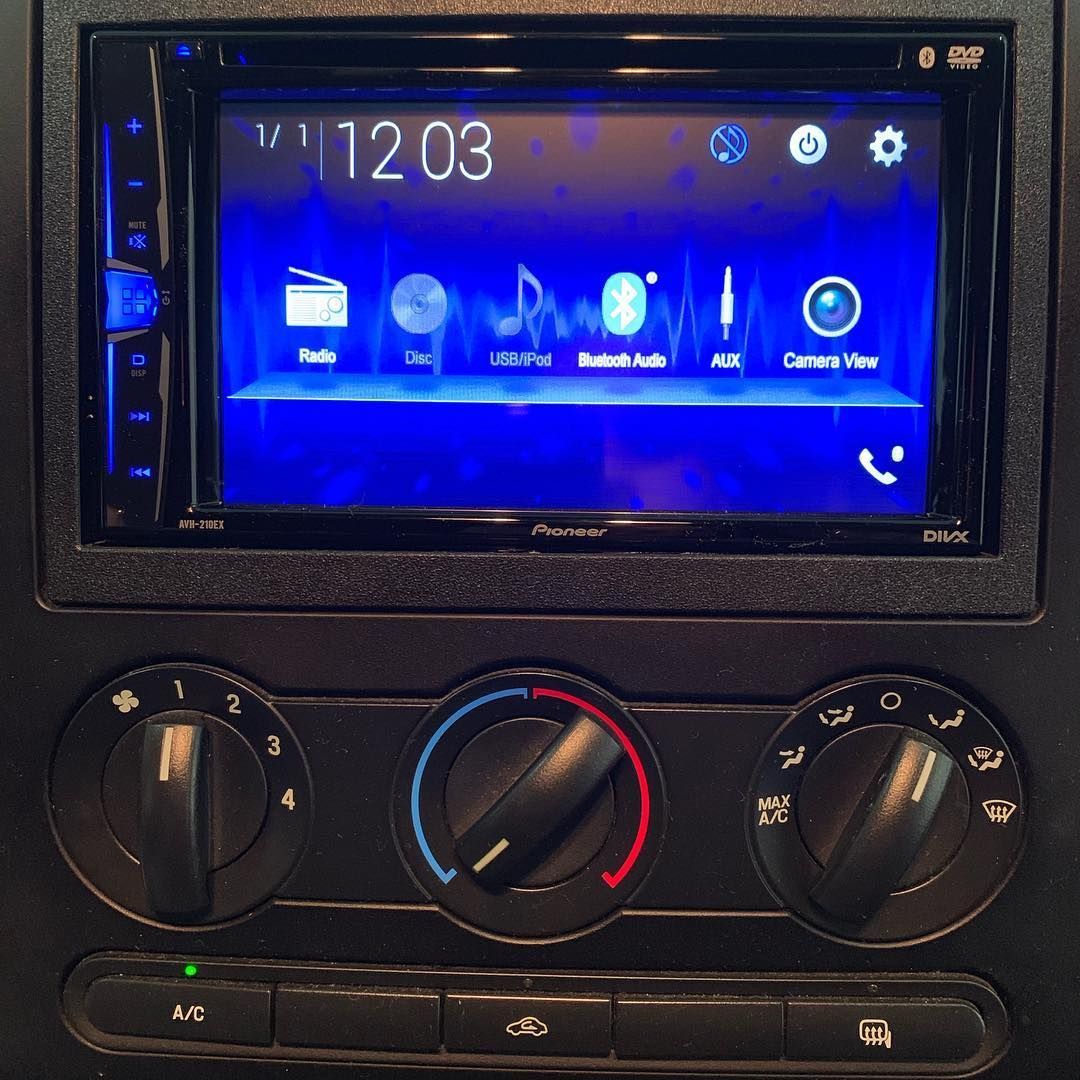 A car radio displays the time as 12:03