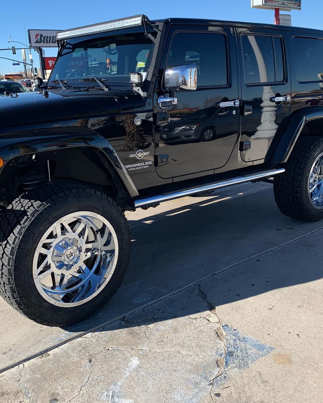 A black jeep is parked on the side of the road.