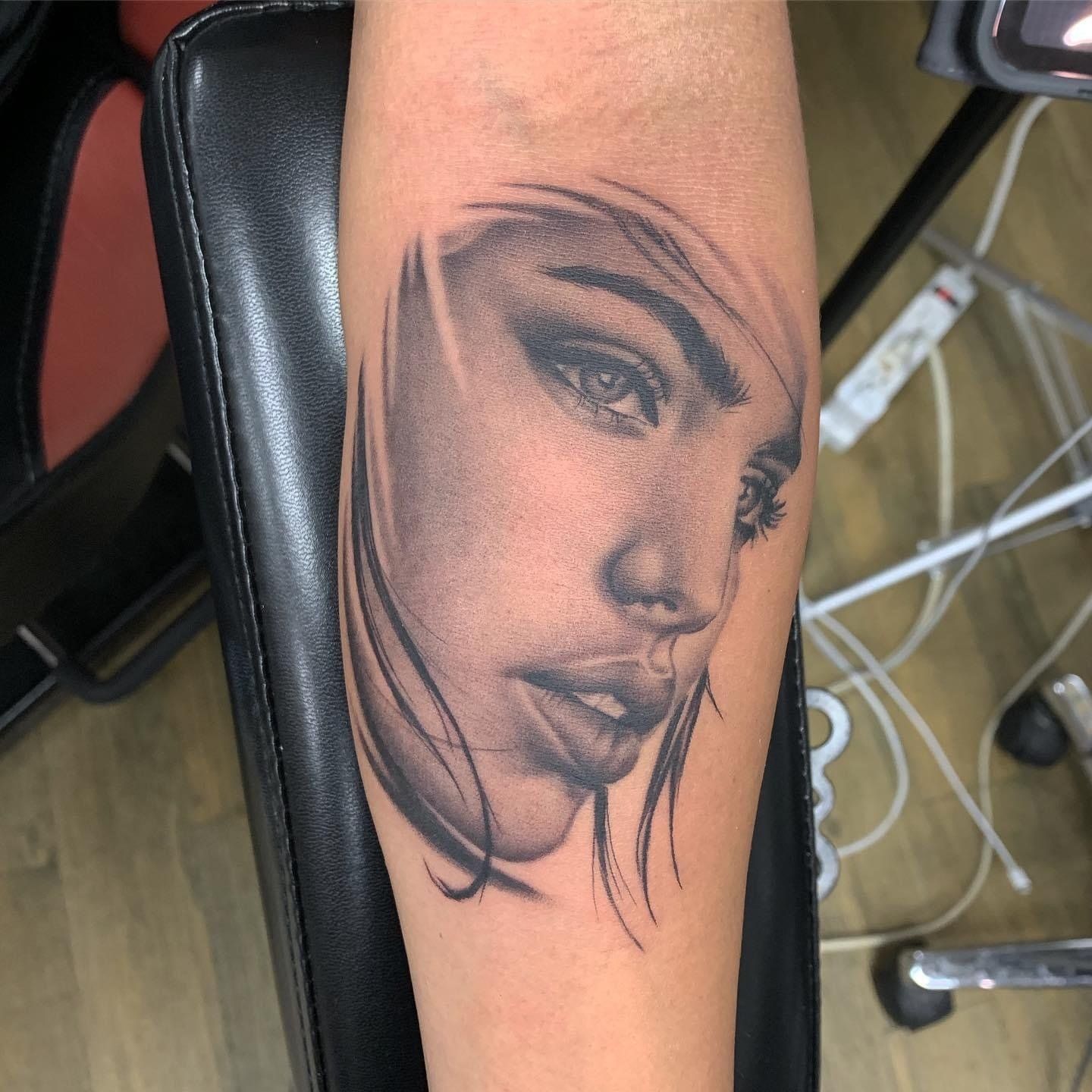 A black and white tattoo of a woman 's face