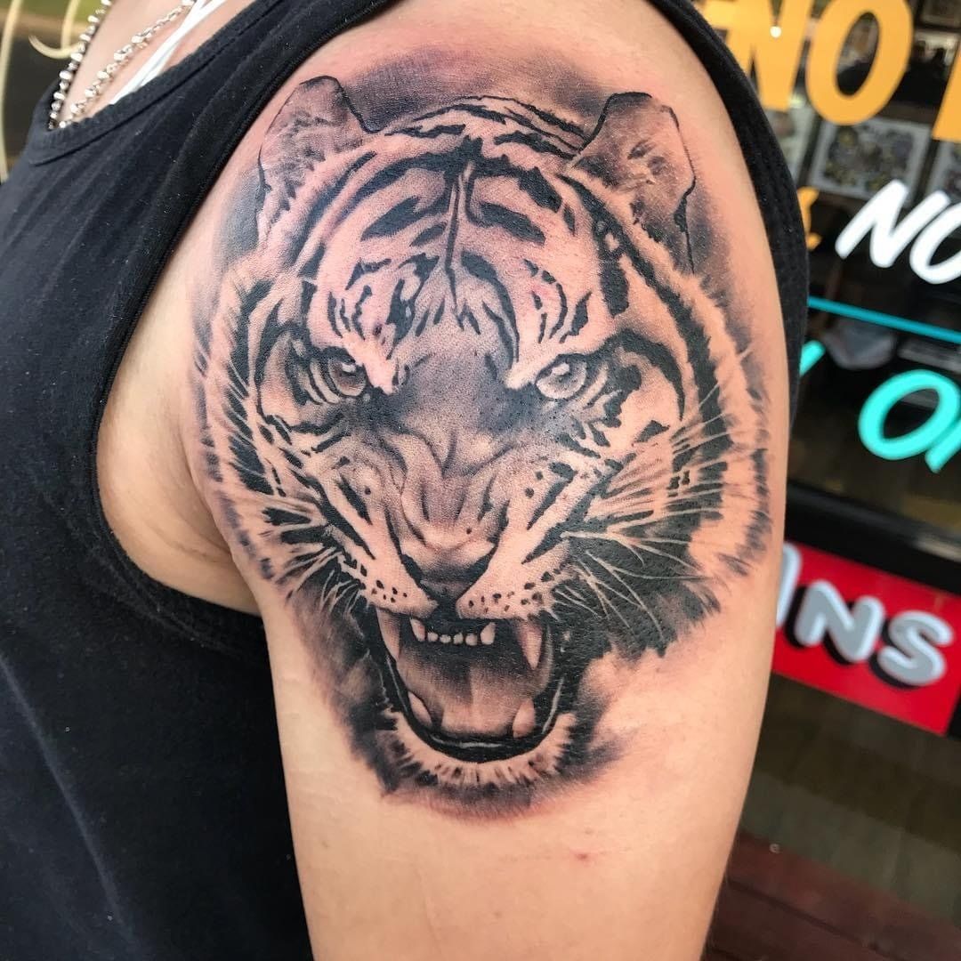 A man has a tattoo of a tiger on his arm