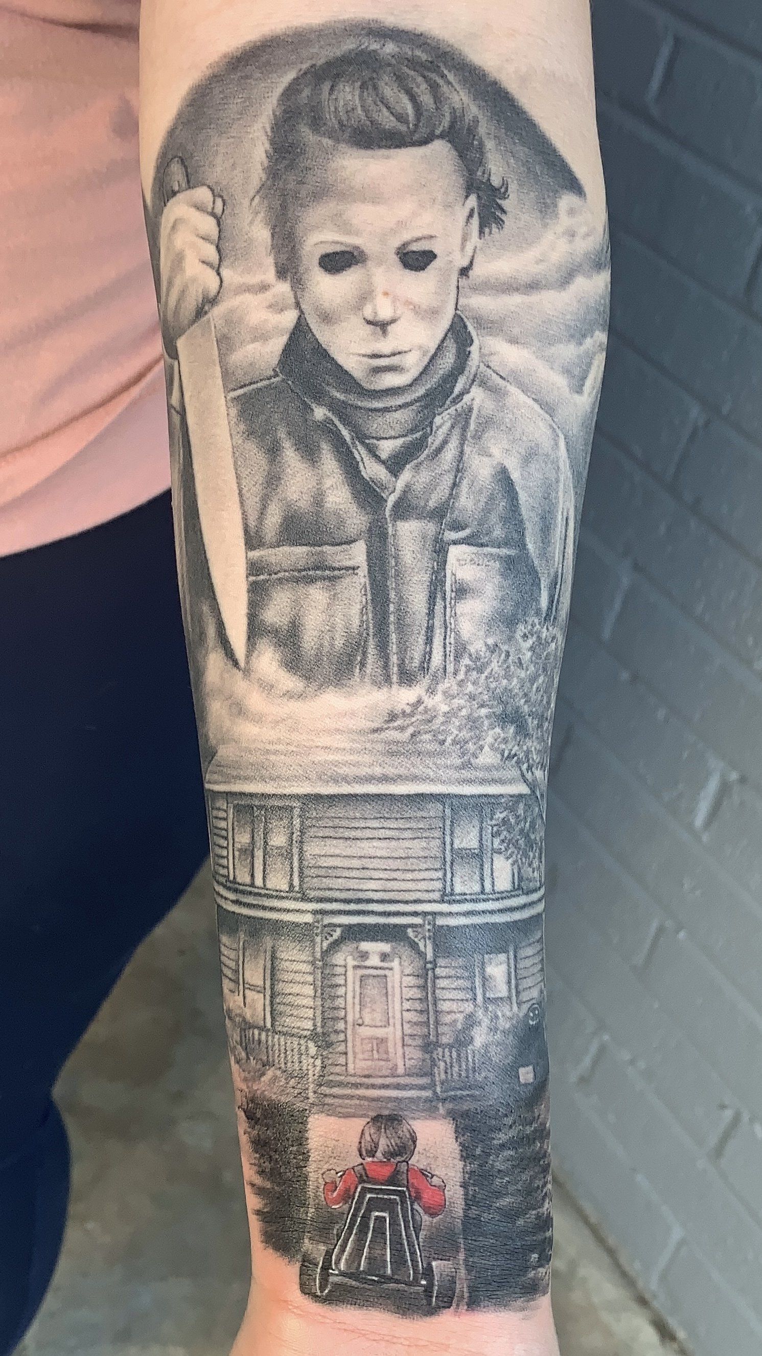A person has a tattoo of michael myers on their forearm.