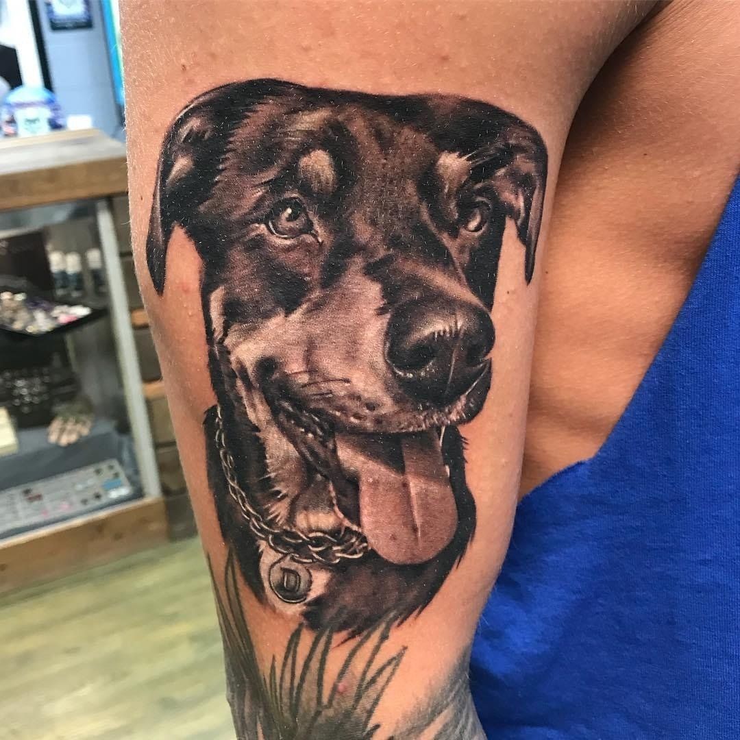 A person has a tattoo of a dog on their arm